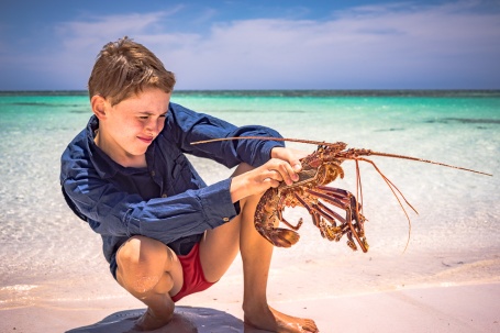 Aidan with caught lobster on the Abrohlos Islands